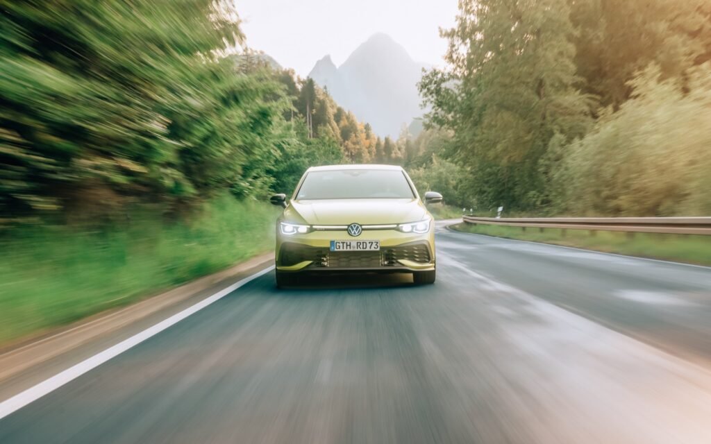Gelber VW Golf während einer Fahrt auf einer Waldstraße