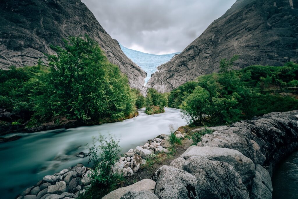 Gebirgsfluss zwischen grünen Bäumen und grauen Felsen