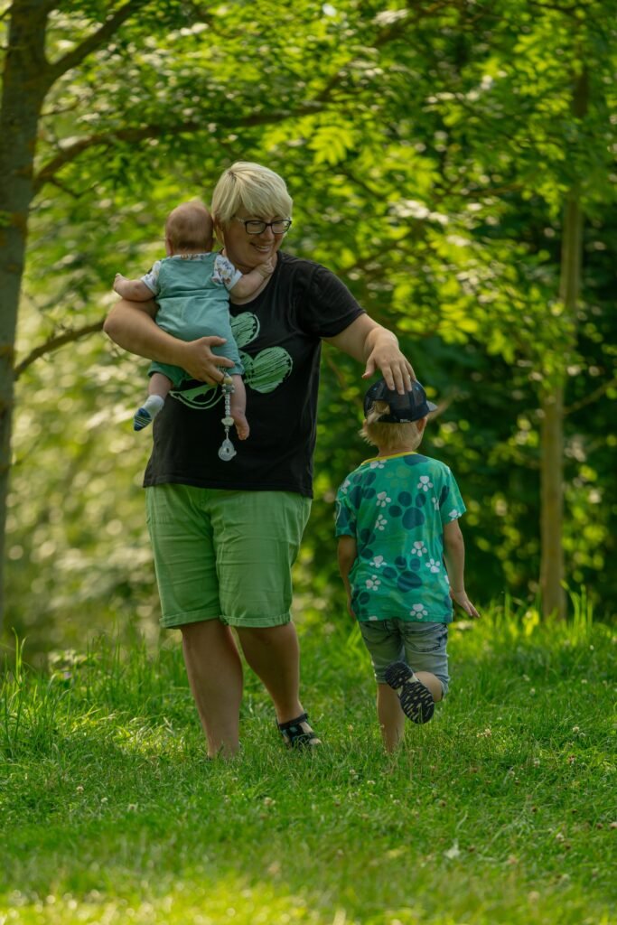 Familie geht gemeinsam einen grünen Waldweg entlang