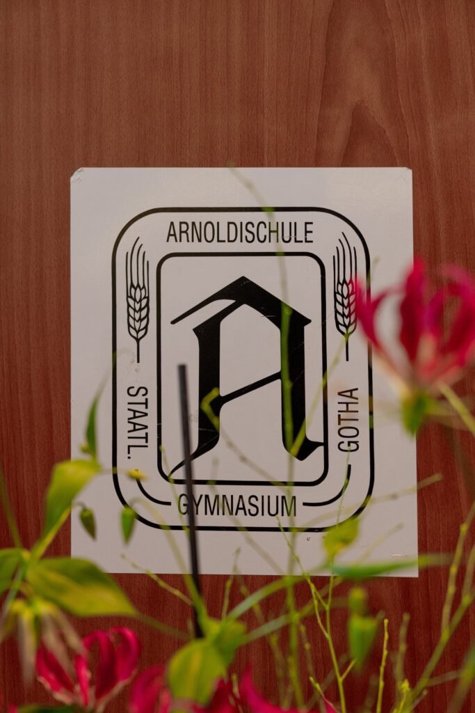 Schild der Arnoldischule im Blumenschmuck