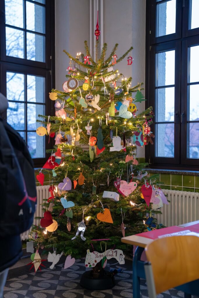 Geschmückter Weihnachtsbaum vor großen Fenstern