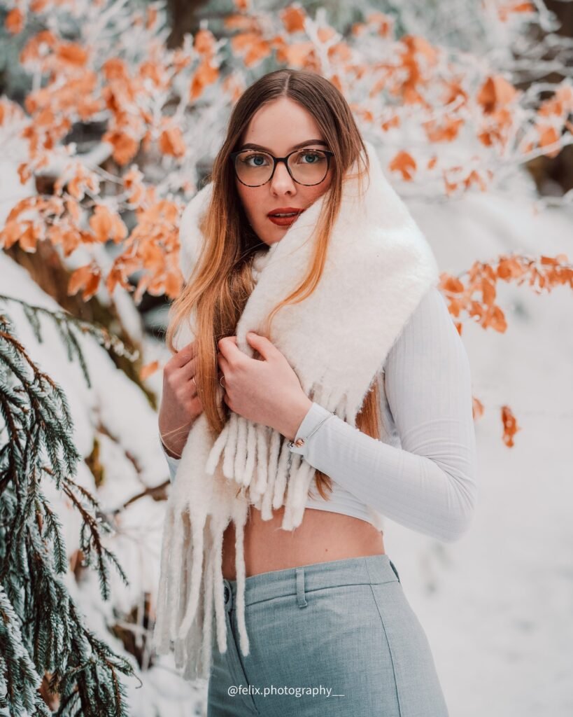 Portrait einer Frau mit hellem Schal vor herbstlichen Blättern
