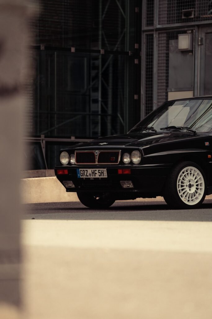 Front eines schwarzen BMW vor einer Industriehalle