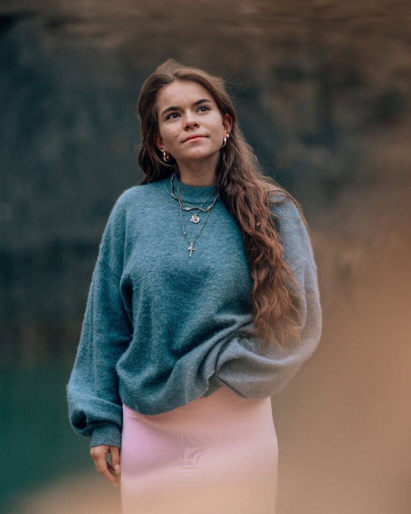 Portrait einer Frau in blaugrünem Pullover vor einer Felswand