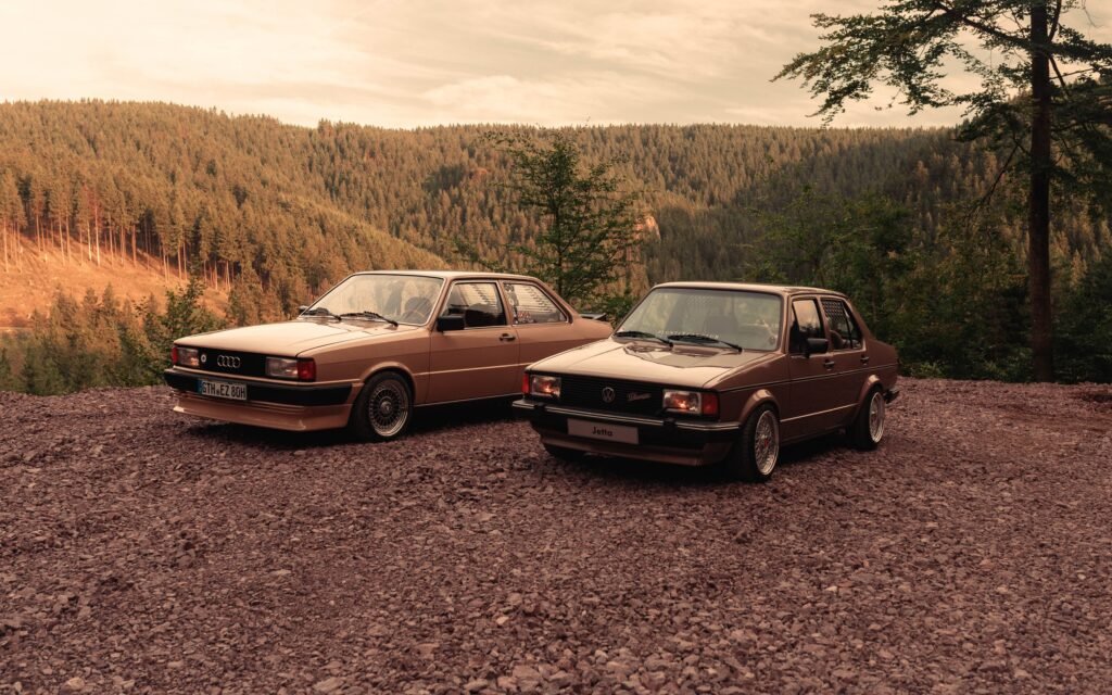 Audi 80 und VW Jetta nebeneinander auf einem Waldparkplatz