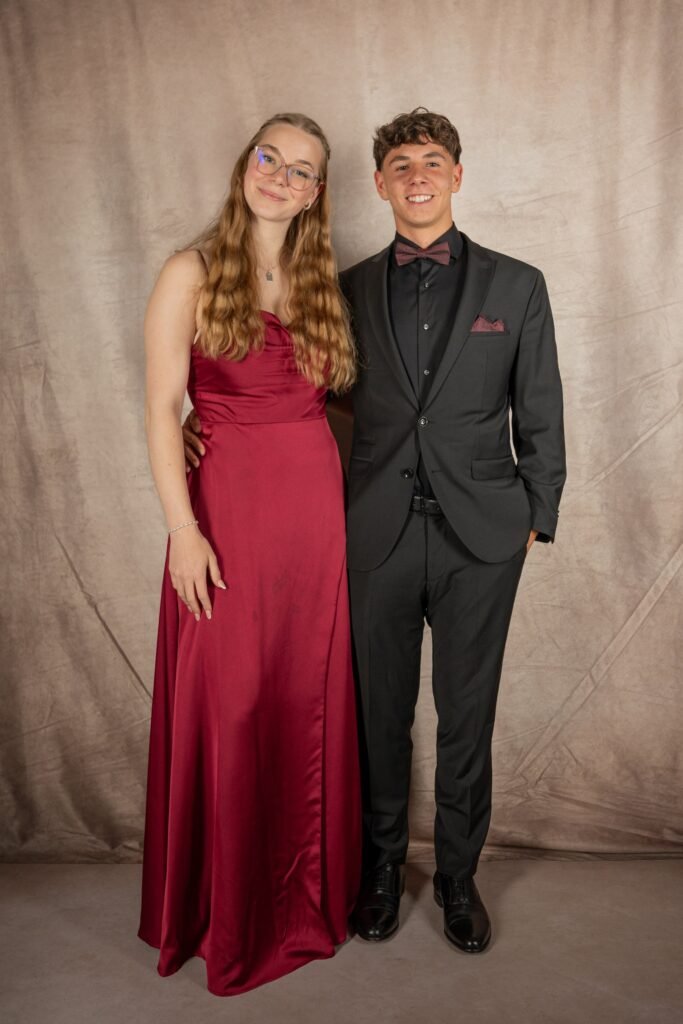 Zwei Gäste in rotem Kleid und dunklem Anzug beim Portrait
