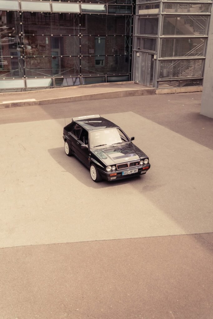 Schwarzer BMW auf einer offenen Industriefläche von oben