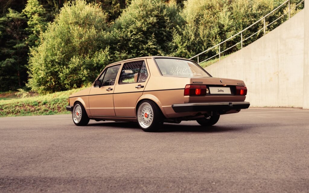 VW Jetta vor einer Betonwand neben einer Straße