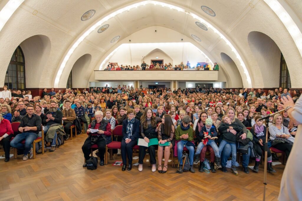 Besetzter Veranstaltungssaal mit gewölbter Decke